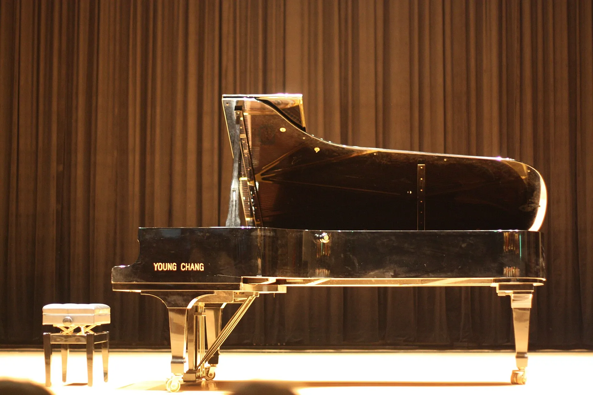 A grand piano on a softly lit stage